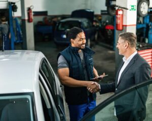 Deux hommes se serrant la main dans un garage automobile
