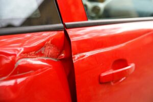 Porte d'une voiture rouge cabossée