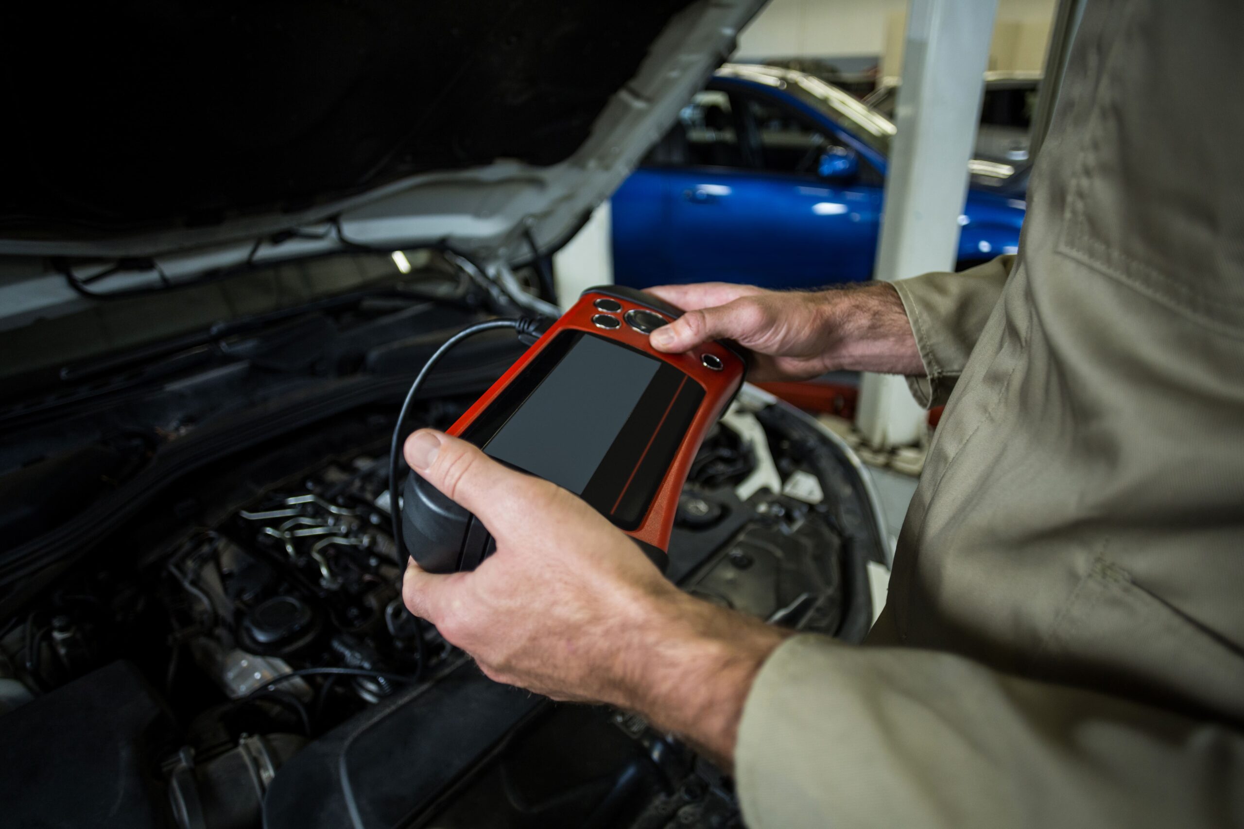 mains-de-mecanicien-en-utilisant-un-outil-de-diagnostic
